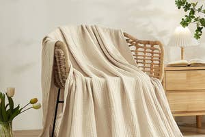 Textured throw blanket draped over a chair in a cozy room setting, suggesting a home decor item for shoppers