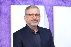 Steve Carell in a black suit posing for a photo with a smile