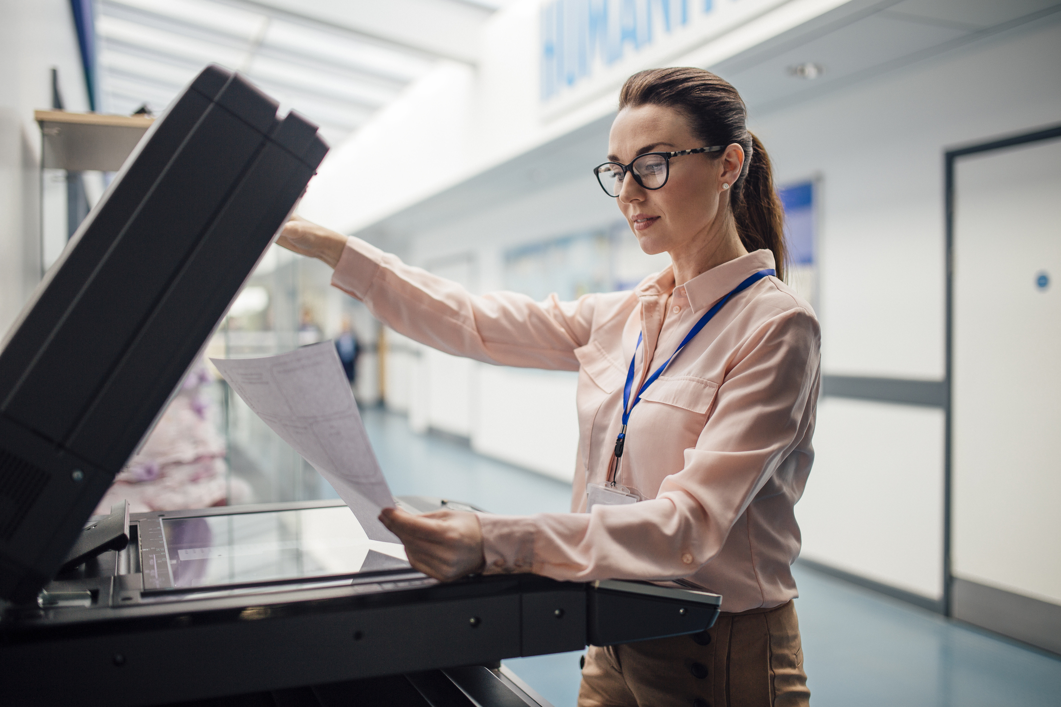 Professional woman using a photocopier in an office setting