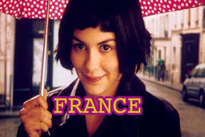 Amelie from the film "Amelie" smiles, holding a polka dot umbrella, with the word "FRANCE" overlaid at bottom