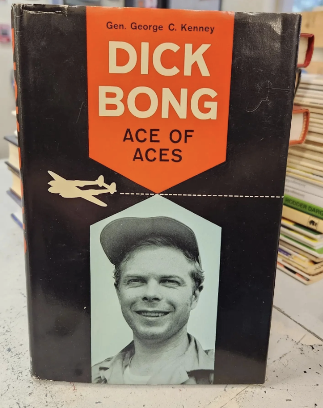 Book titled "Dick Bong Ace of Aces" by Gen. George C. Kenney, featuring a man in a pilot's cap on the cover