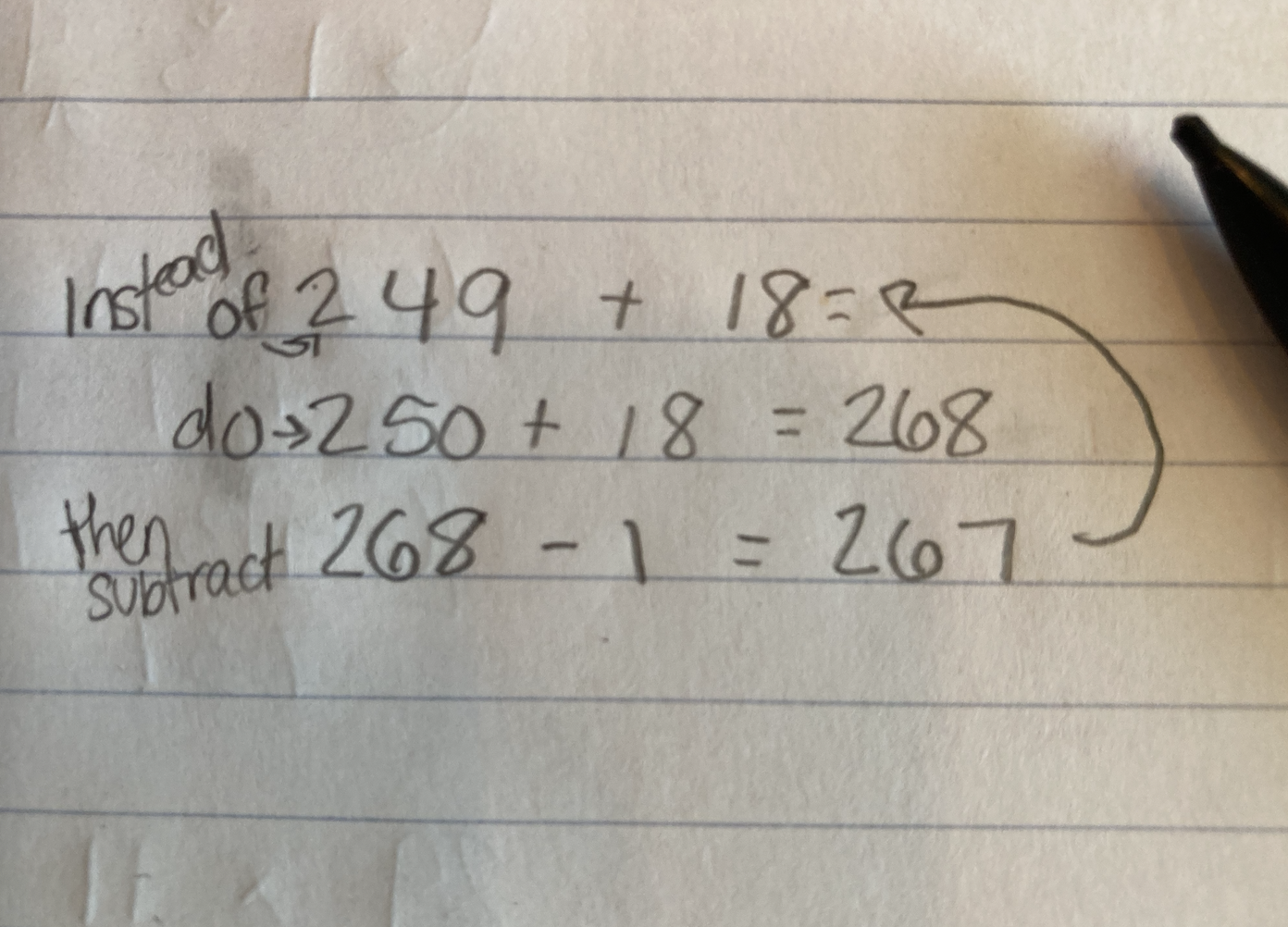 Handwritten math problem on paper with a calculation mistake corrected for summing 250 and 18, then subtracting 1