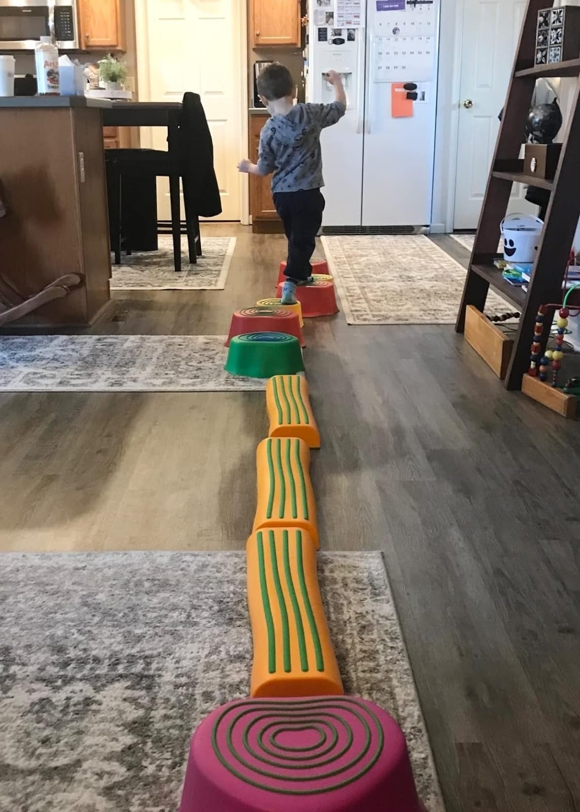 Child balancing connected  colorful stepping stones successful  a kitchen, practicing coordination and play   successful  a location  setting