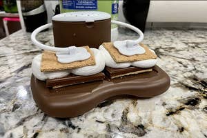 reviewer image of the s'mores maker holding two s'mores