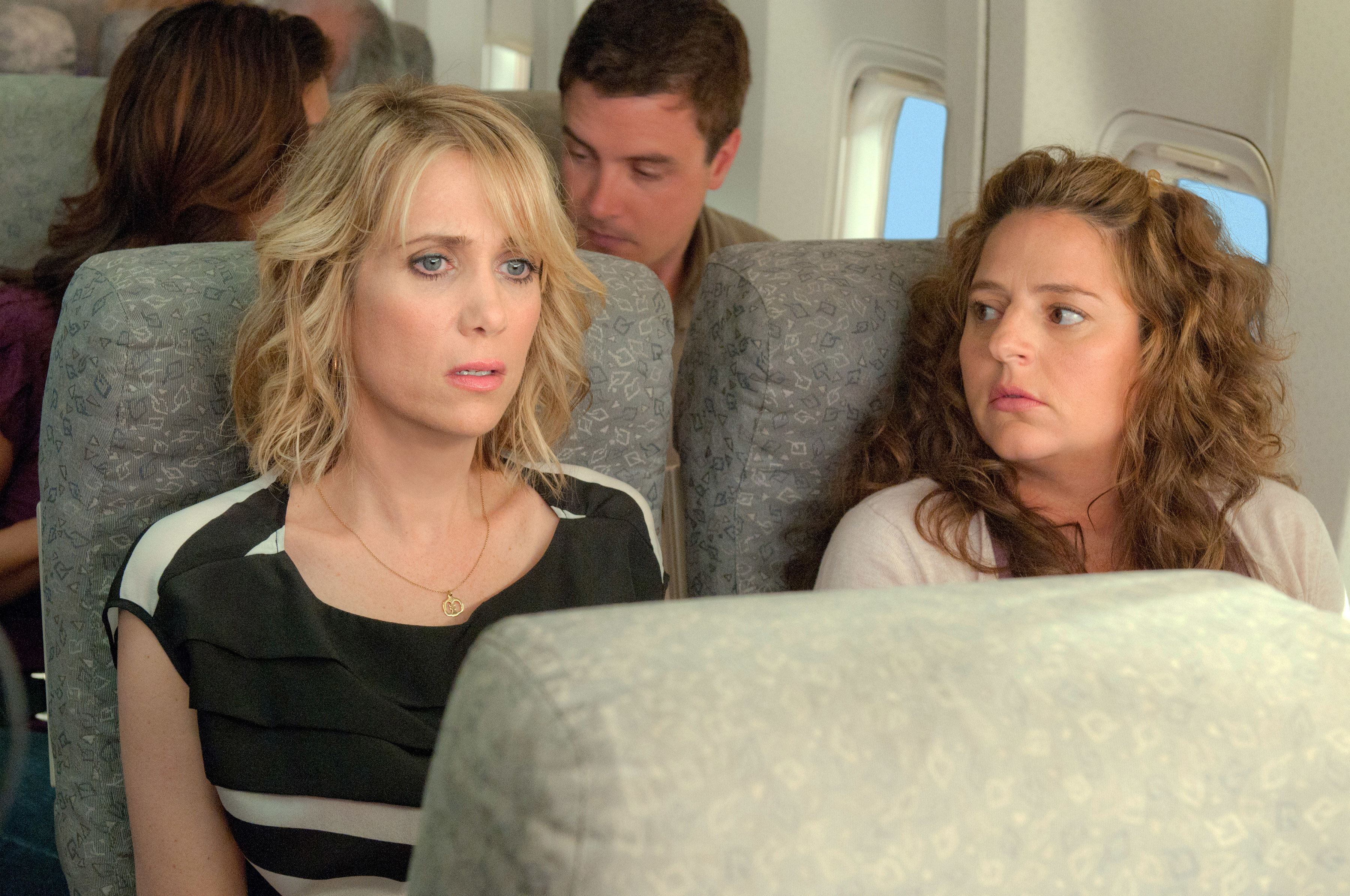 Kristen Wiig seated by Annie Mumolo on a plane during a scene in Bridesmaids