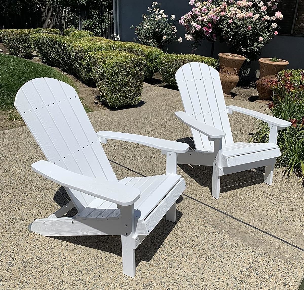 Two white Adirondack chairs on a patio, suitable for outdoor furnishings