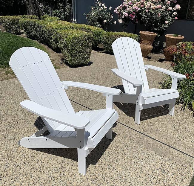 Two achromatic Adirondack chairs connected a patio, suitable for outdoor furnishings
