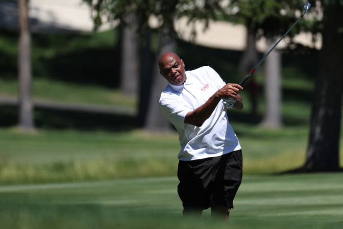 A man swings a golf club on a course; focus on technique rather than attire