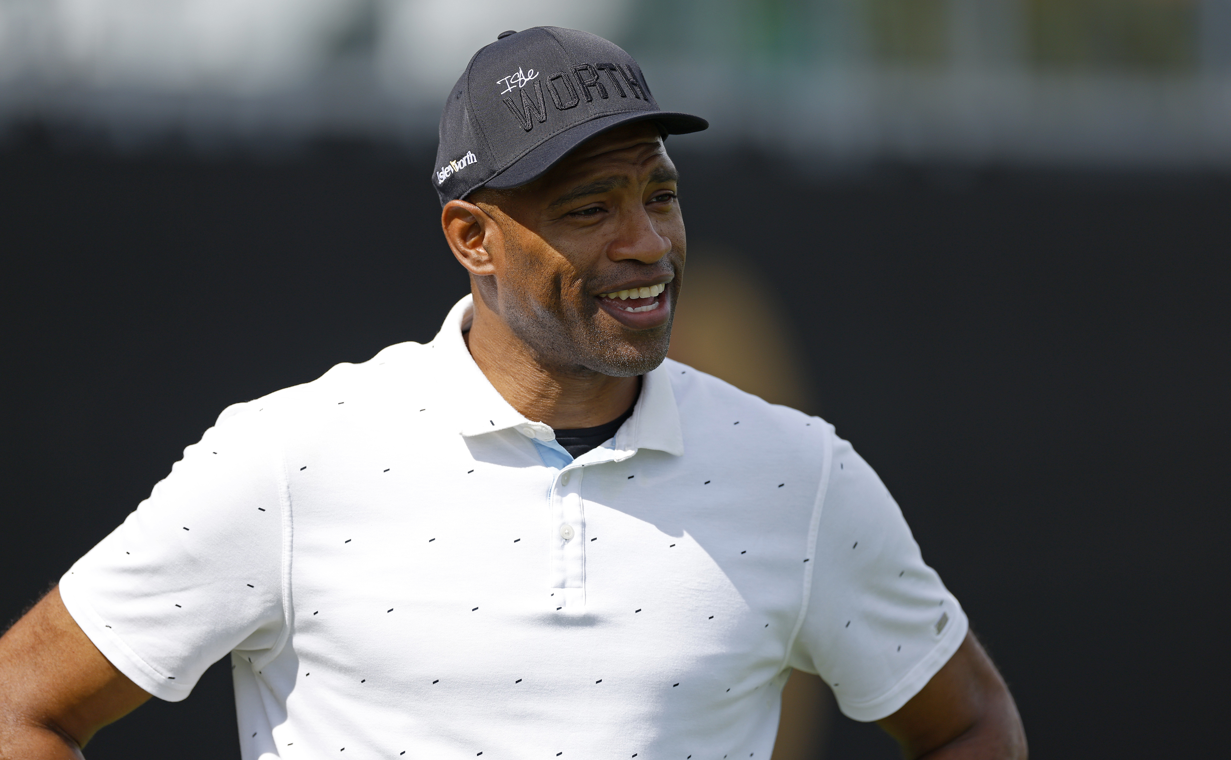 Smiling athlete in a polo shirt and cap on a golf course