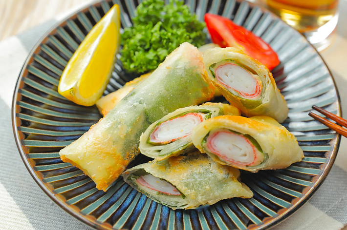 皿の上にサーモンと野菜が巻かれた春巻きが盛り付けられている。