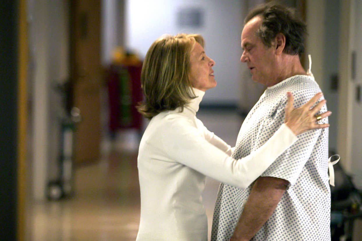 Two actors in a hospital scene, the woman in white comforting the man in a hospital gown