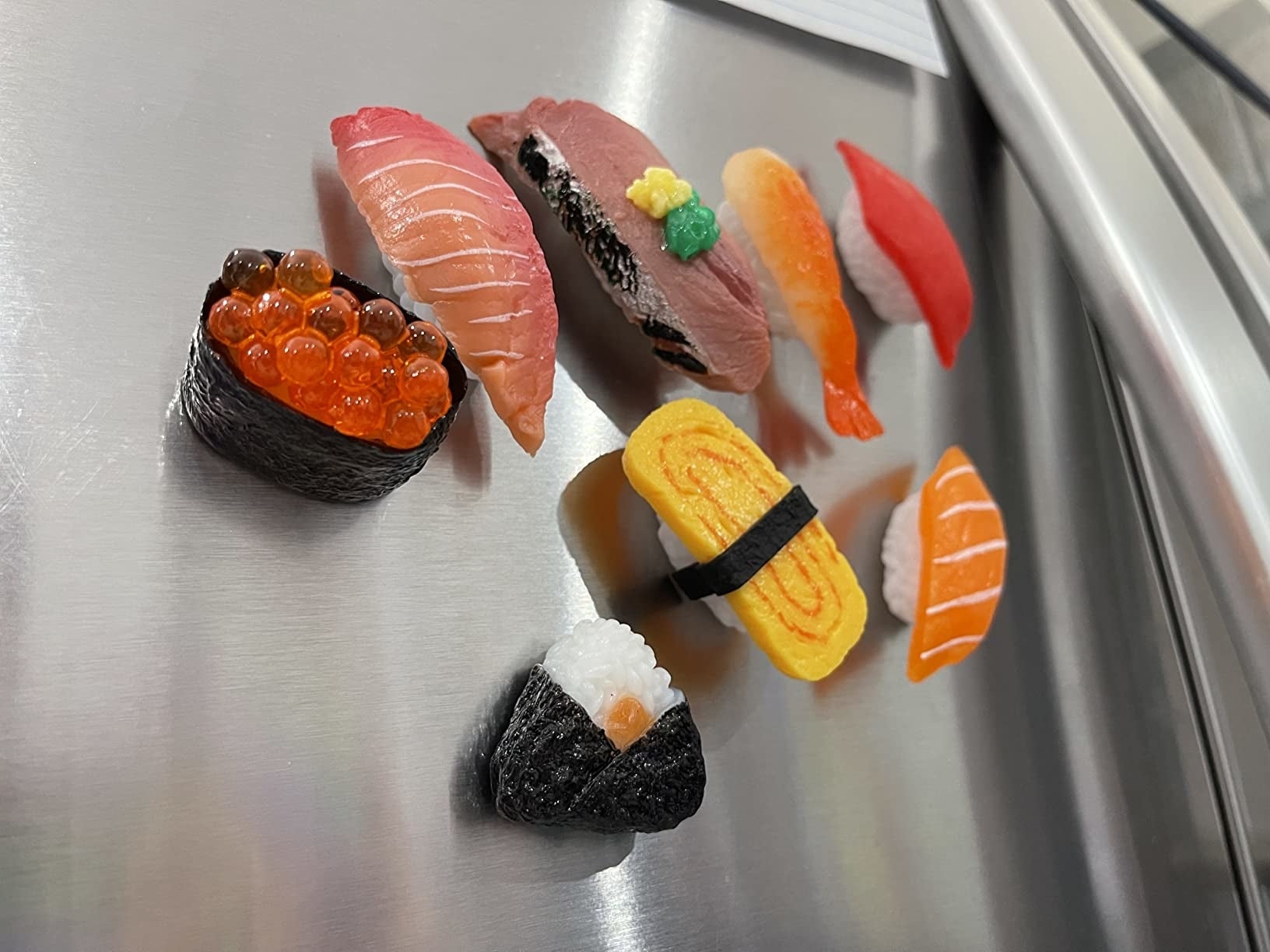 Berbagai potongan sushi disusun di lemari es pengulas