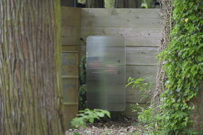 木々に囲まれた金属製のドア。