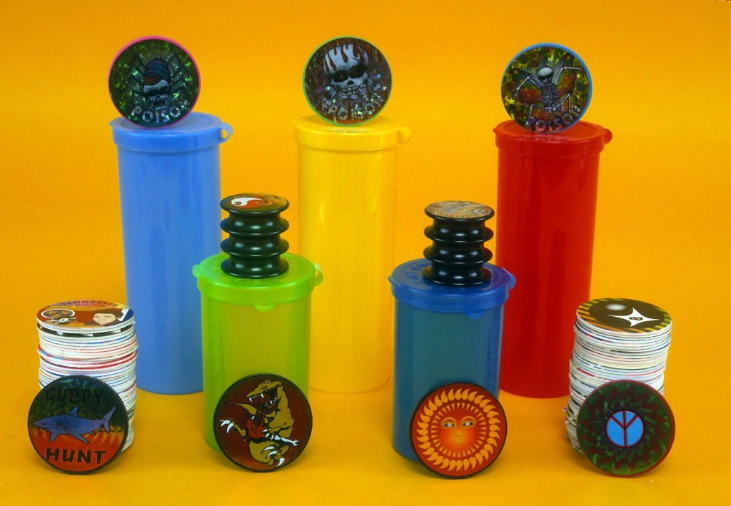 Various colored Pogs and slammers on tubes, reminiscent of the '90s game craze