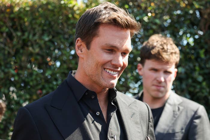 A closeup of Tom Brady with a man in the background