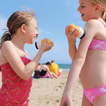 Two children connected a formation applying sunscreen with the Solar Buddies