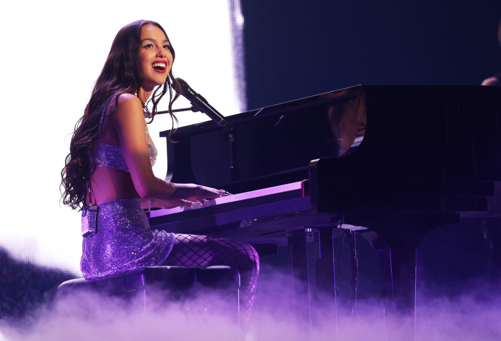 Olivia in sparkling crop top and skirt playing piano on stage