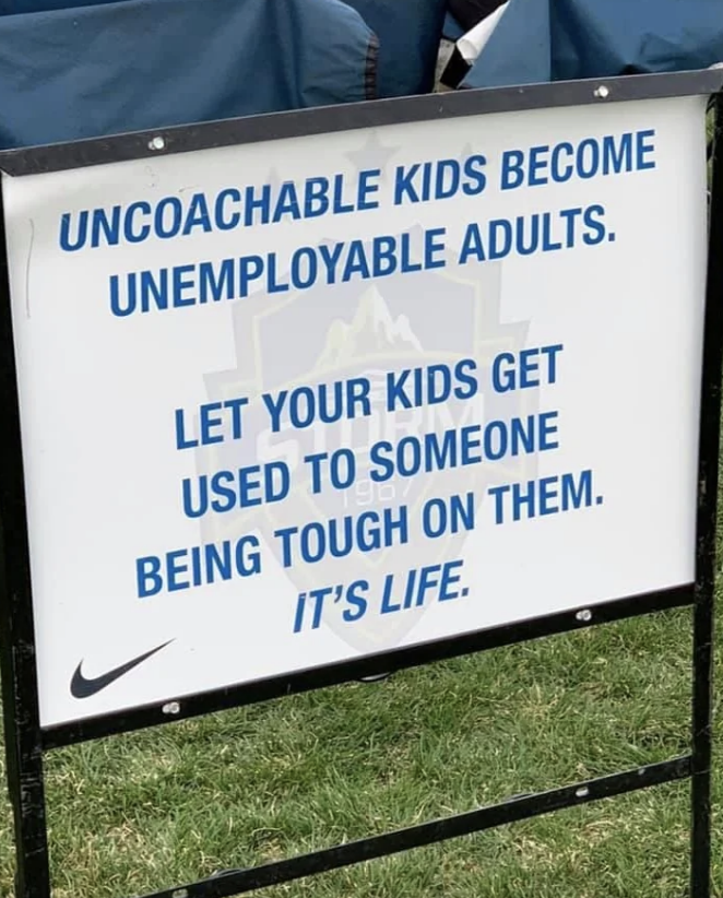 Sign reads "Uncoachable kids become unemployable adults. Let your kids get used to someone being tough on them. It's life."