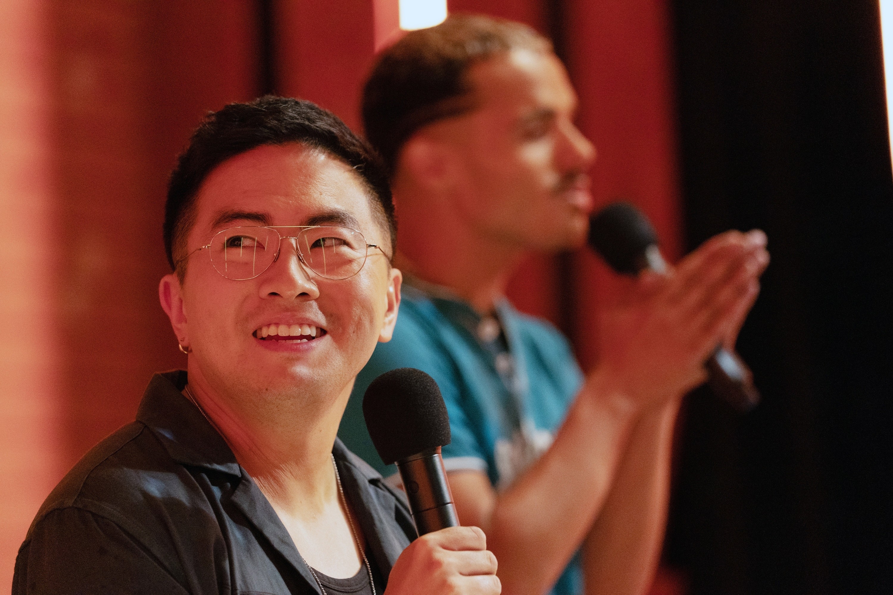 in a scene, Bowen holds a mic on stage