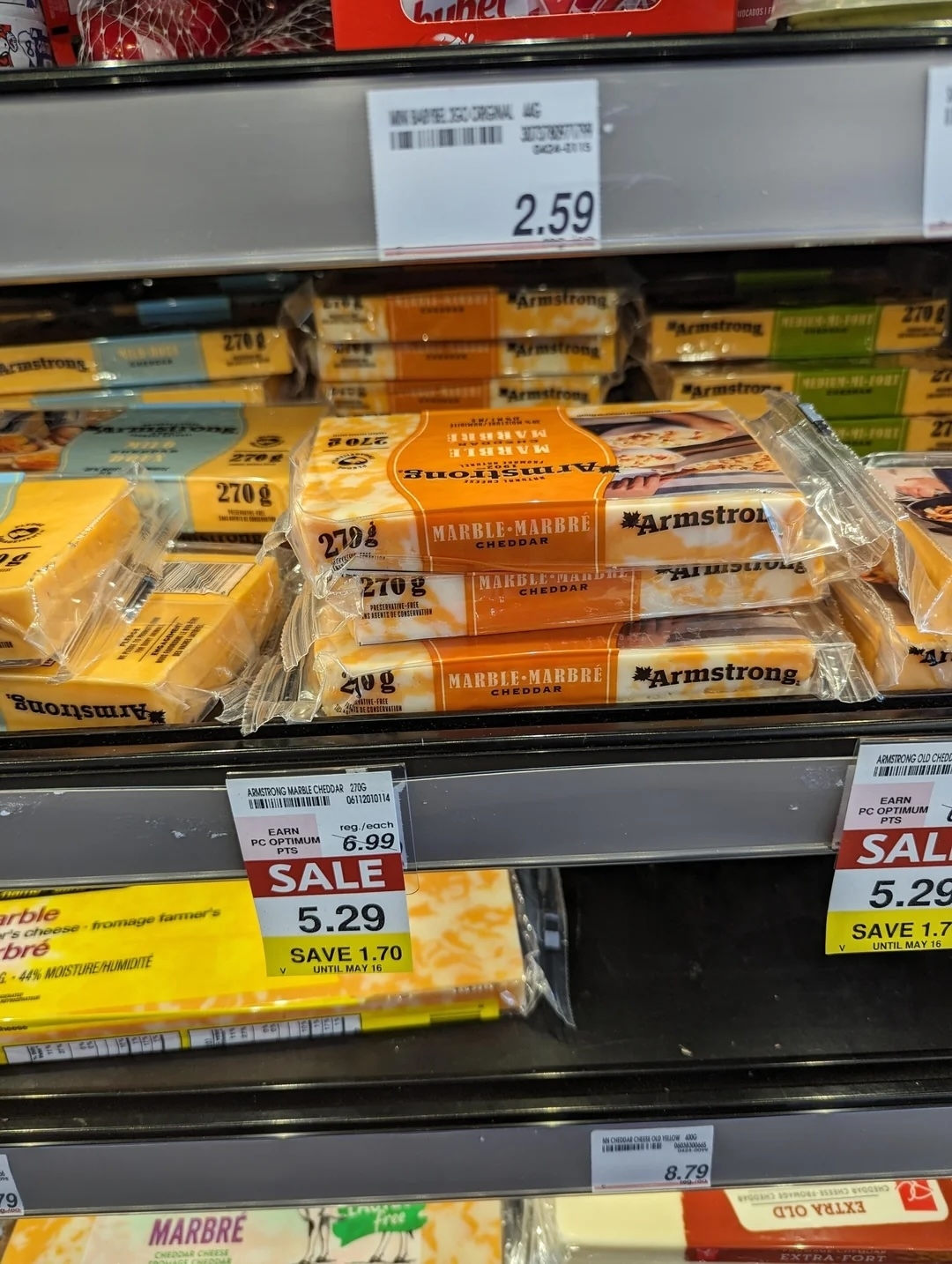 Packages of Armstrong Marble Cheese on store shelf with sale tags displaying reduced prices