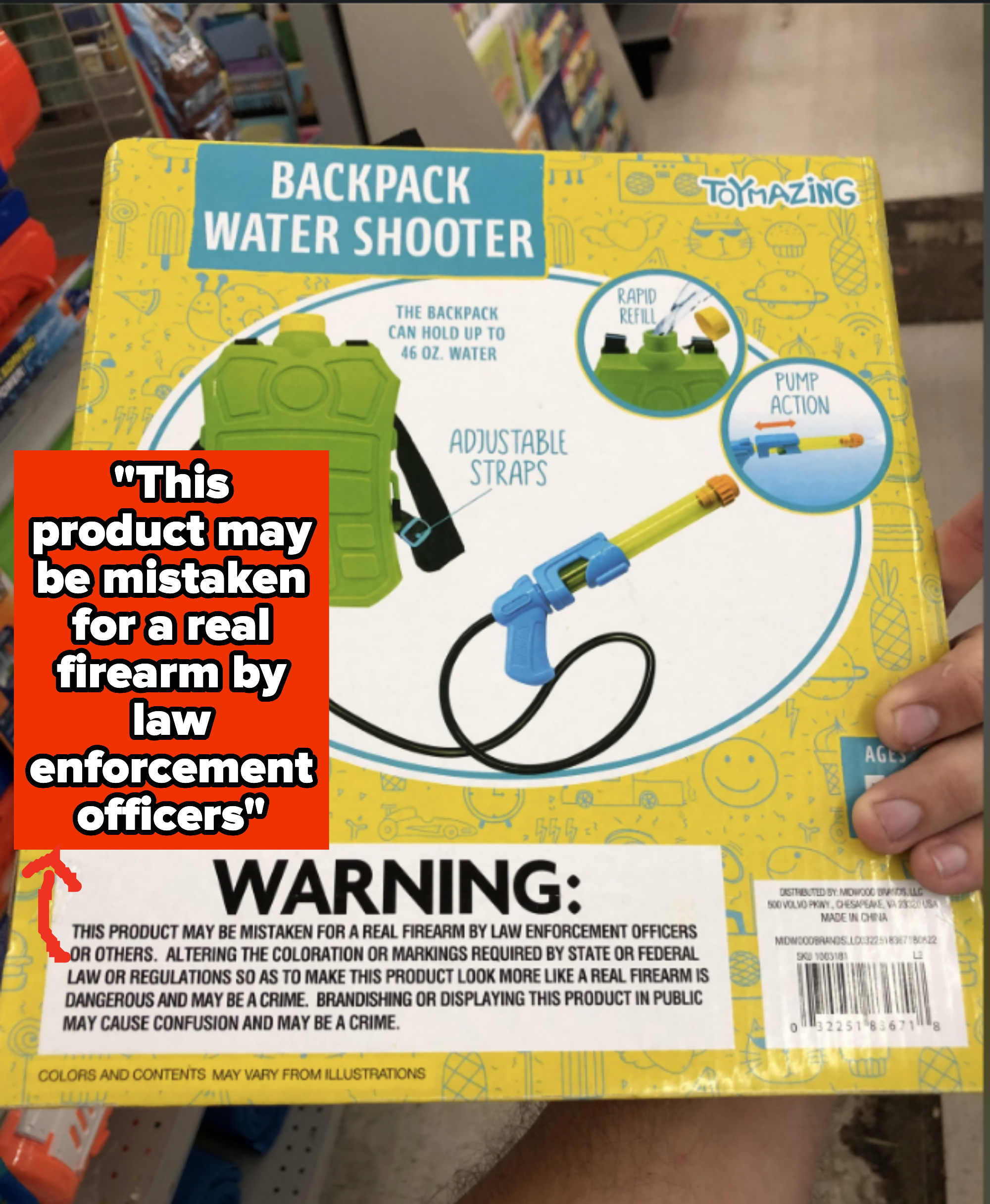 A person holding a backpack water shooter toy package with a warning label about mistaken identity by law enforcement
