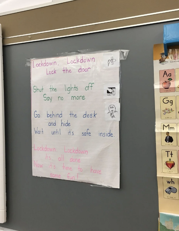 Child's handwritten lockdown drill instructions on a classroom wall