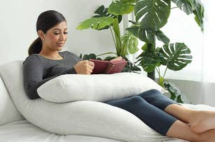 Woman lounging on a beanbag, reading a book, in a casual outfit suitable for a shopping article