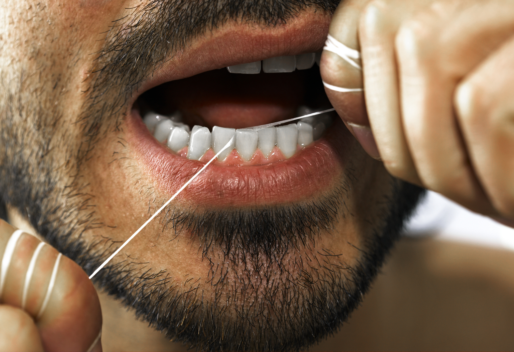 Close-up of a person flossing their teeth