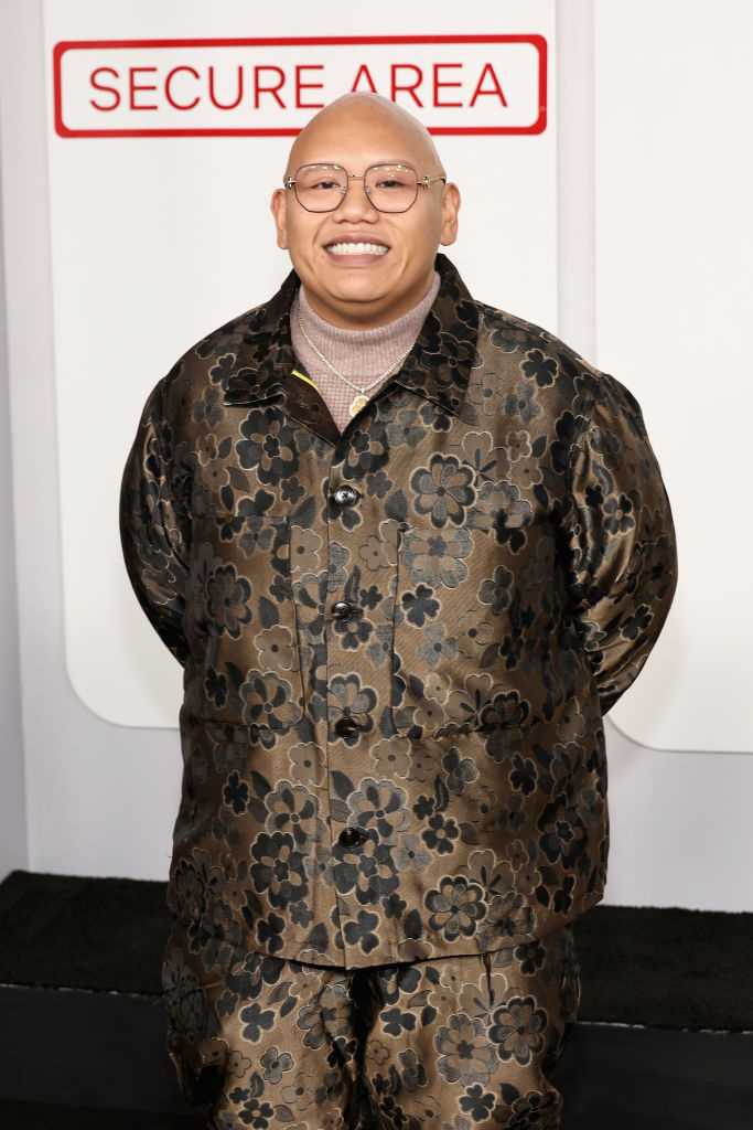 Jacob in a floral-patterned suit standing in front of a sign that reads "SECURE AREA."