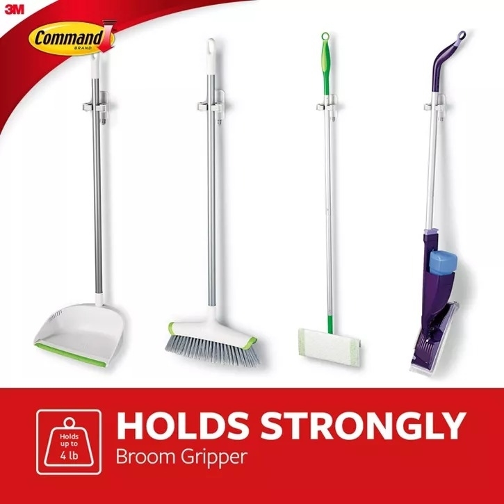 Four different types of brooms and mops held upright by Command Broom Grippers by 3M with a 'Holds Strongly' claim