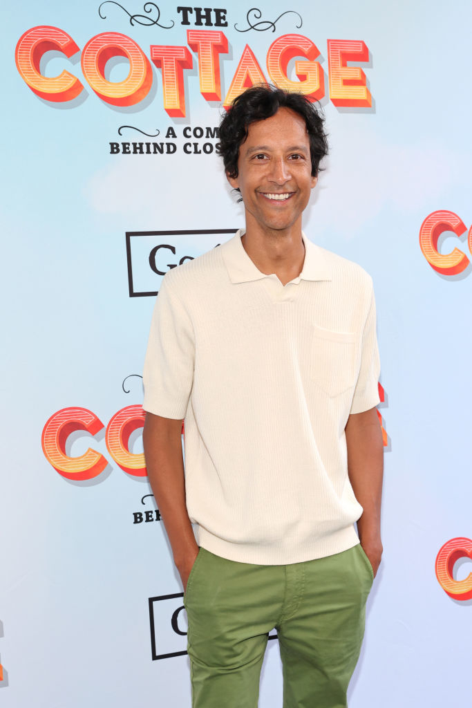 Danny smiling at event, wearing casual short-sleeved shirt and green trousers