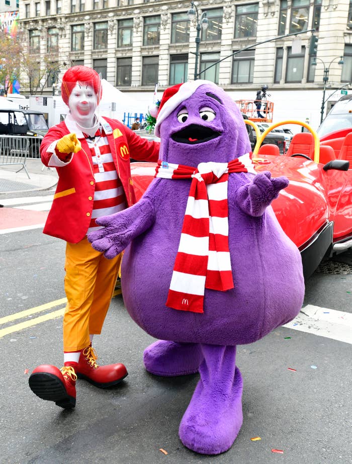 Ronald McDonald with red shoes and striped socks; Grimace in purple outfit with red and white scarf