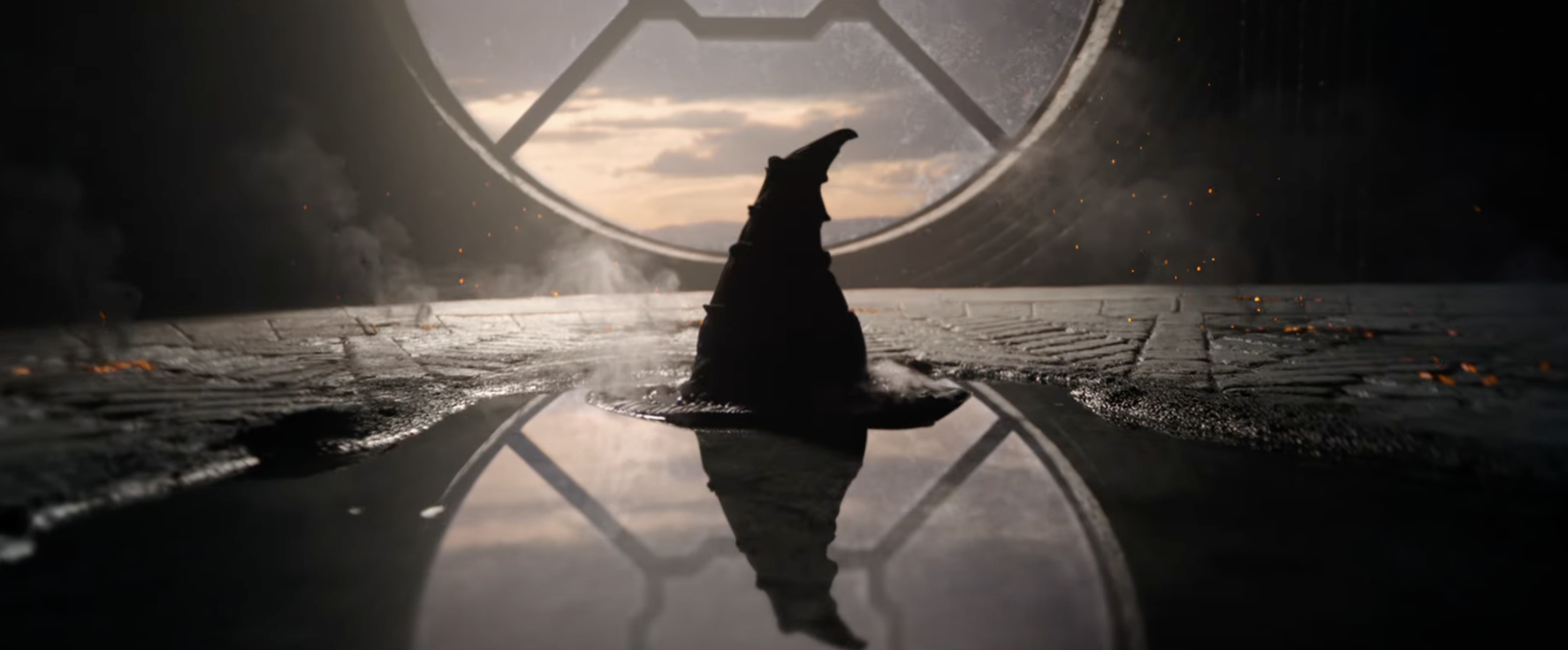 Silhouetted figure standing before a large, window-like structure, with an emblem at the top, in a dramatic, dimly lit scene