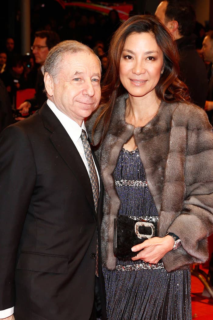 Two people posing together; one person in a suit and the other in a fur-trimmed outfit with a sparkly dress