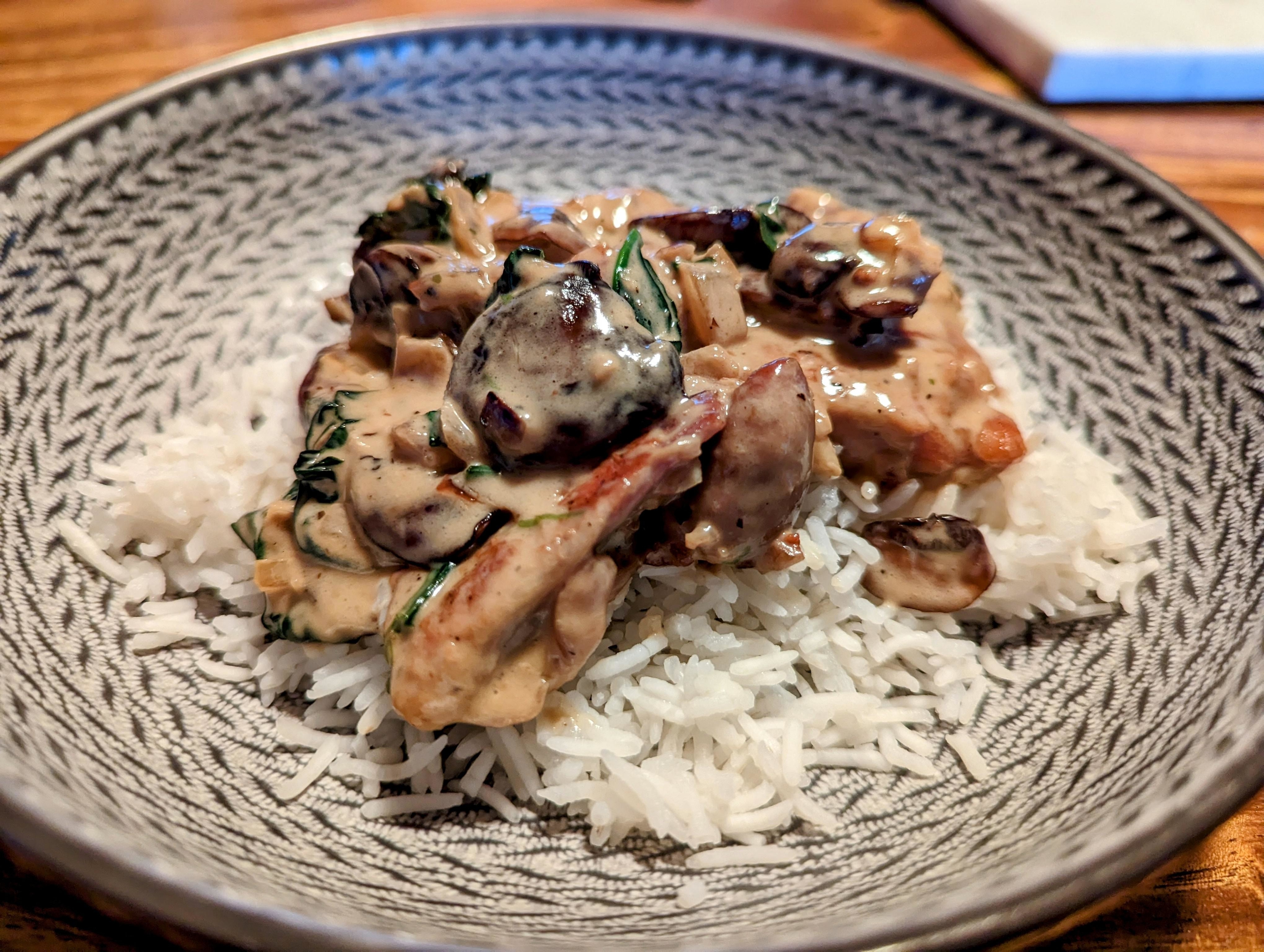 Creamy chicken and mushroom sauce over rice served in a bowl