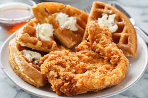 Plate with fried chicken and waffles, accompanied by syrup on the side