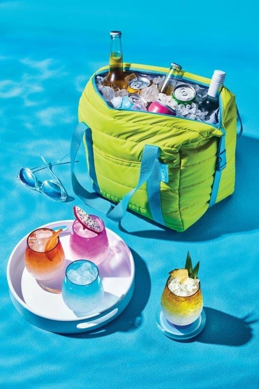 Portable cooler with bottles and a tray with various drinks beside it