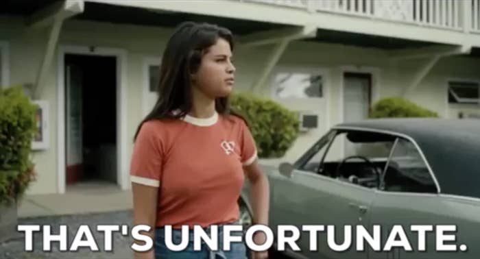 Woman in t-shirt stands outside by a car with text "THAT'S UNFORTUNATE."