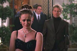 Rory Gilmore crying in a black dress and tiara with Logan standing behind her.