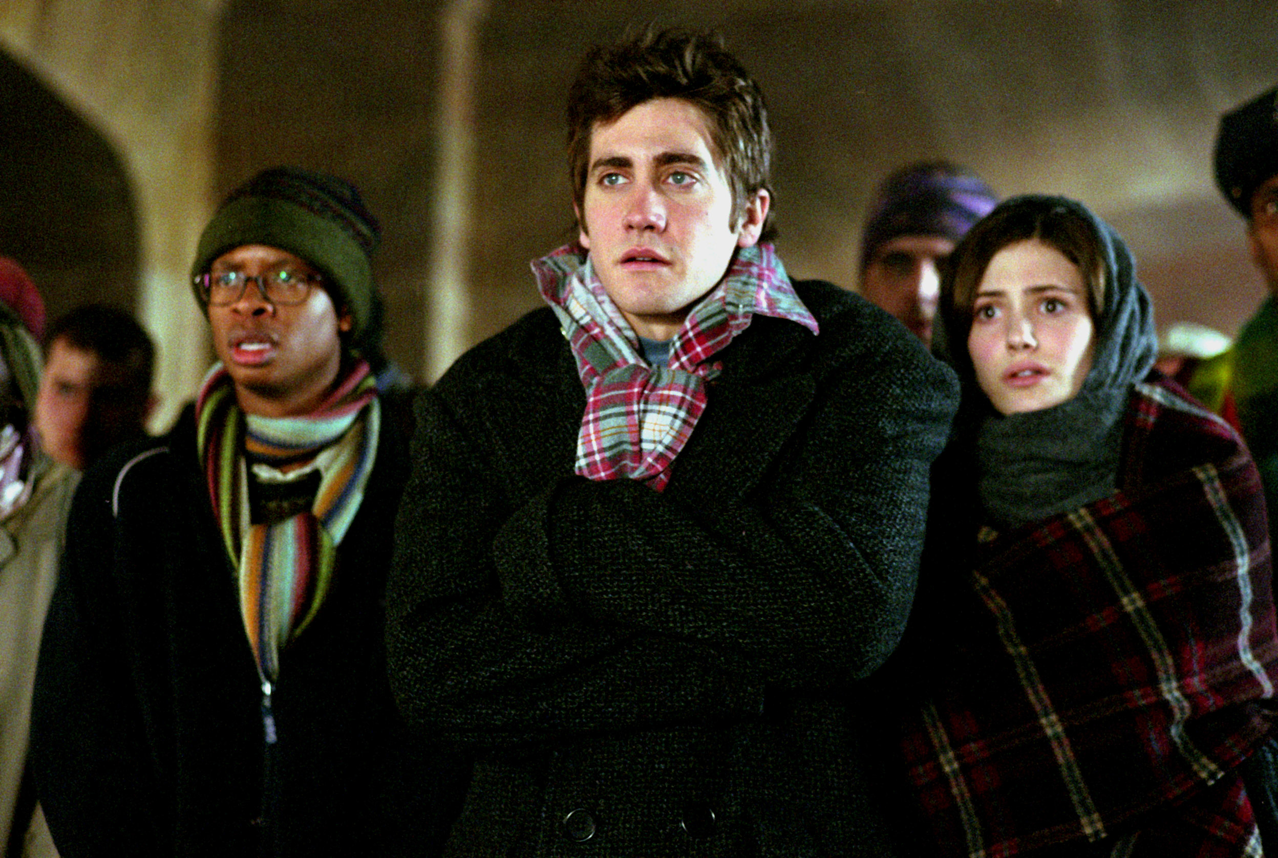 Lee Jordan, Oliver Wood, and Katie Bell, characters from Harry Potter, watching an event, in winter attire