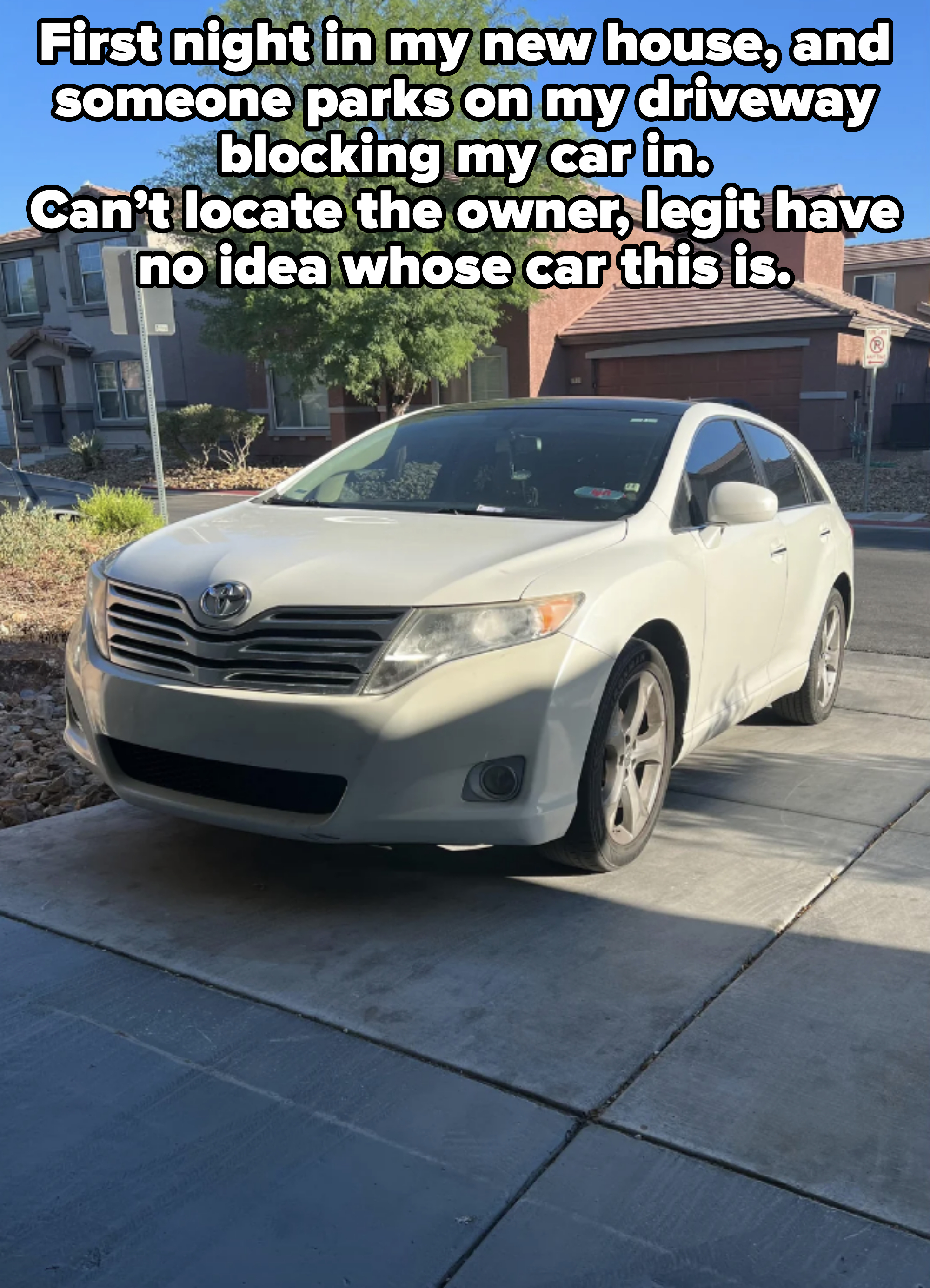 A white Toyota sedan parked on a residential street in front of houses