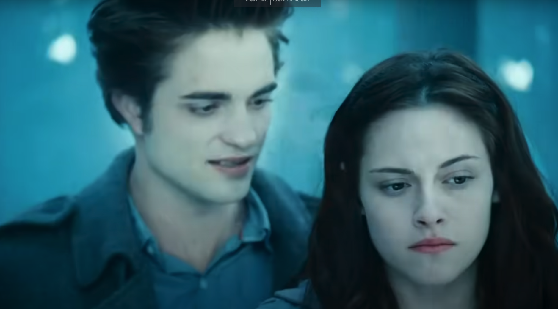 Edward and Bella, characters from Twilight, stand close with intense expressions