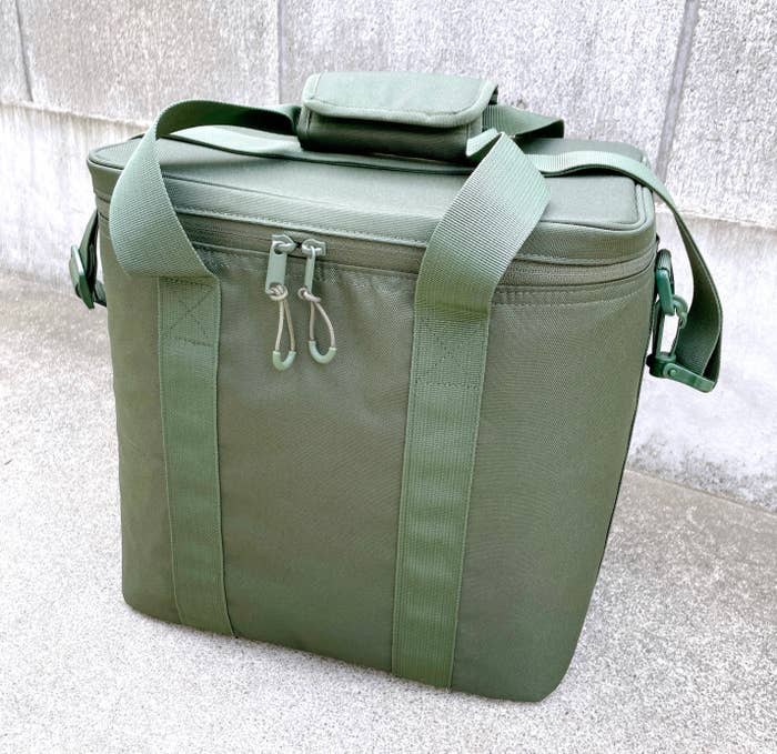 緑のクーラーバッグがコンクリートの上に置いてあります。