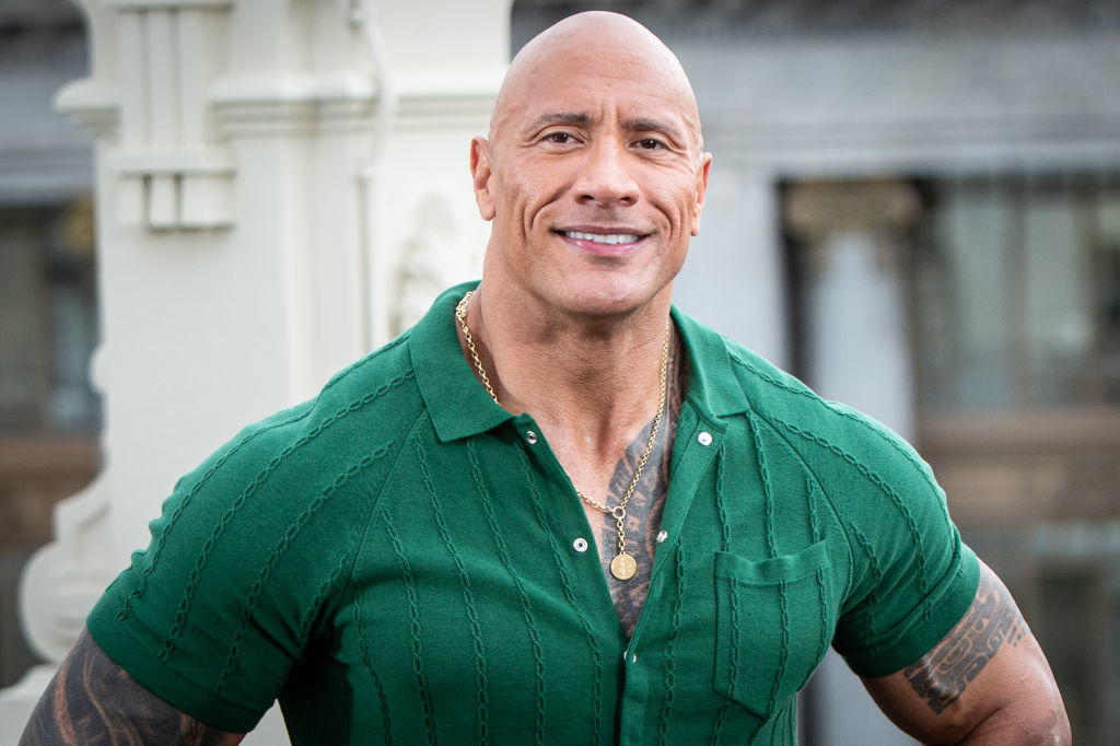 Dwayne &quot;The Rock&quot; Johnson smiling in a green shirt, standing outdoors