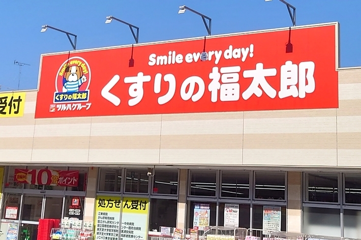看板に「Smile every day! くすりの福太郎」とあり、店頭に商品が並ぶ日本の薬局です。