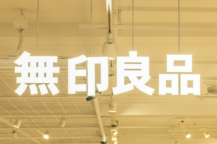 Interior of a store with shoppers and illuminated signage with Asian characters
