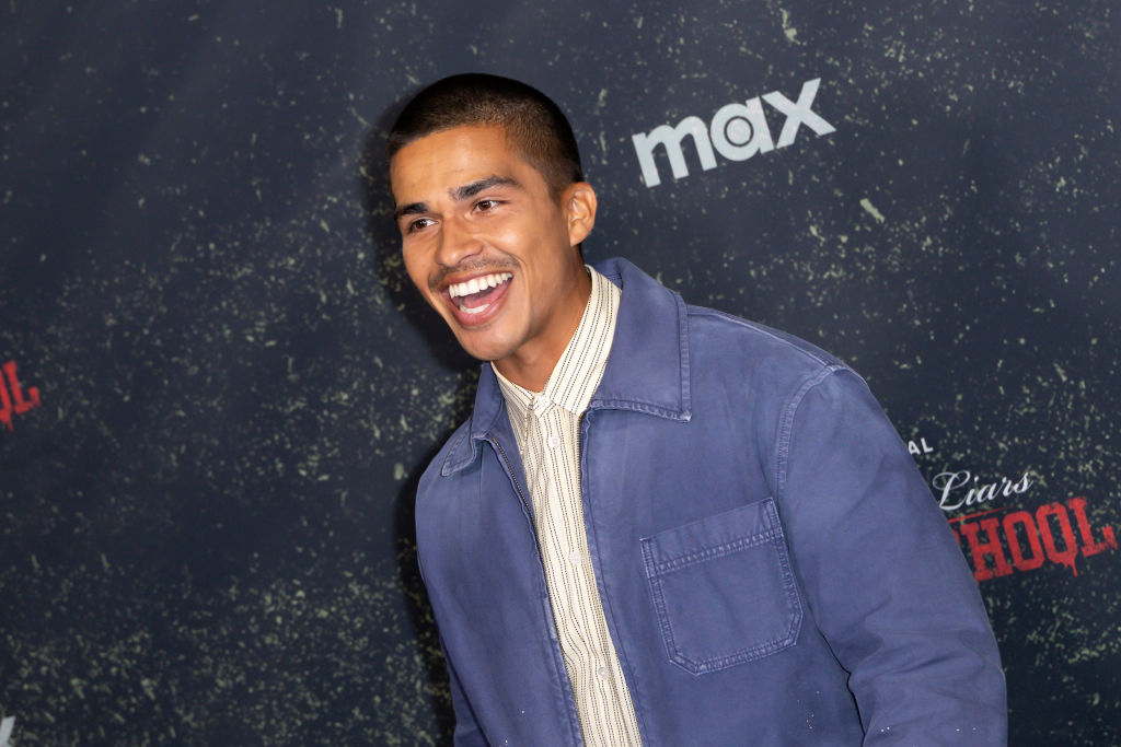 Person smiling at an event, wearing a zip-up jacket and a collared shirt
