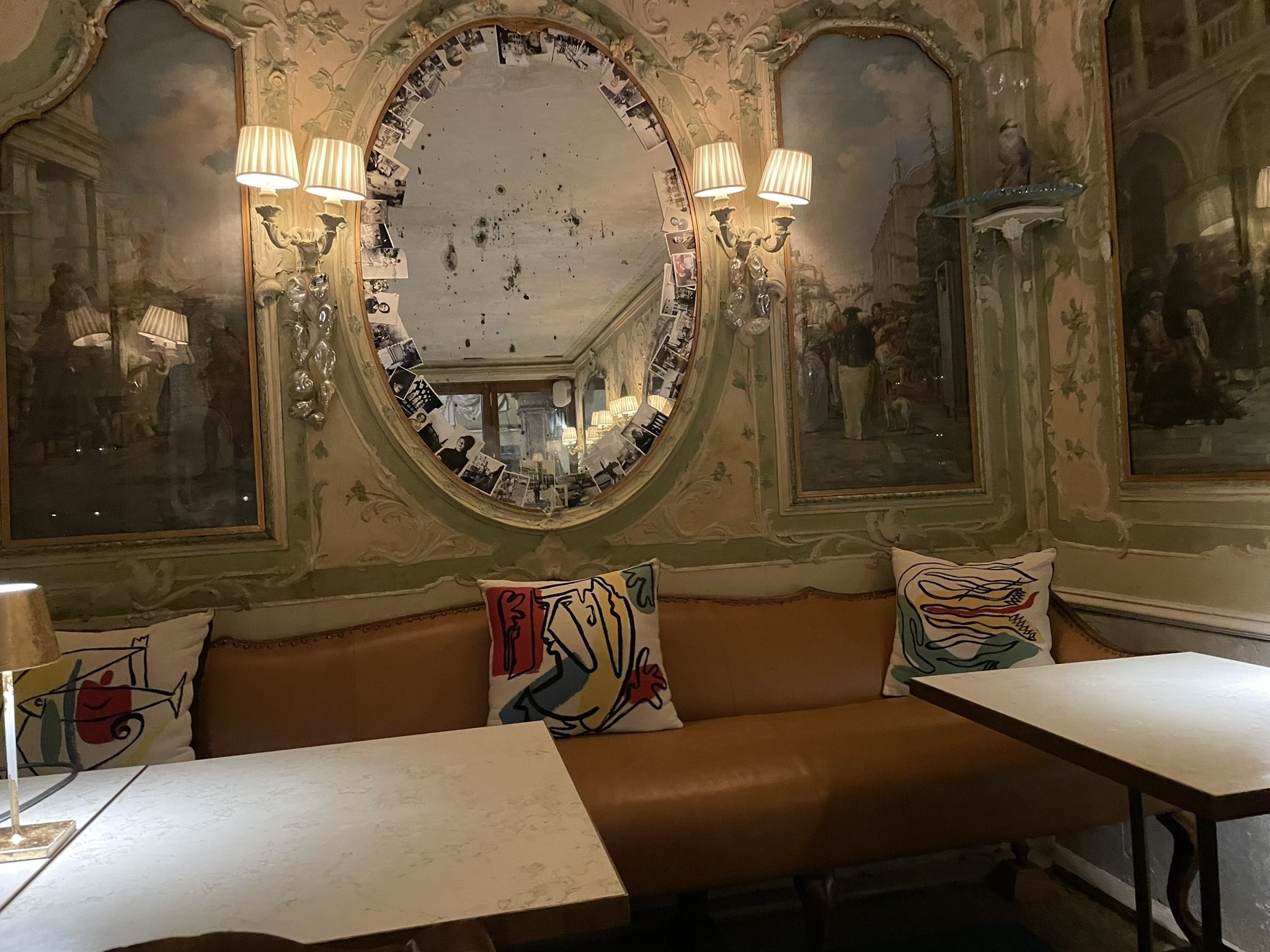 レストランの壁面に鏡とアートなクッションがあるボックス席です。