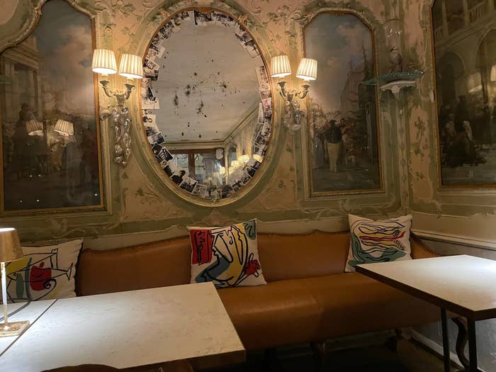 レストランの壁面に鏡とアートなクッションがあるボックス席です。