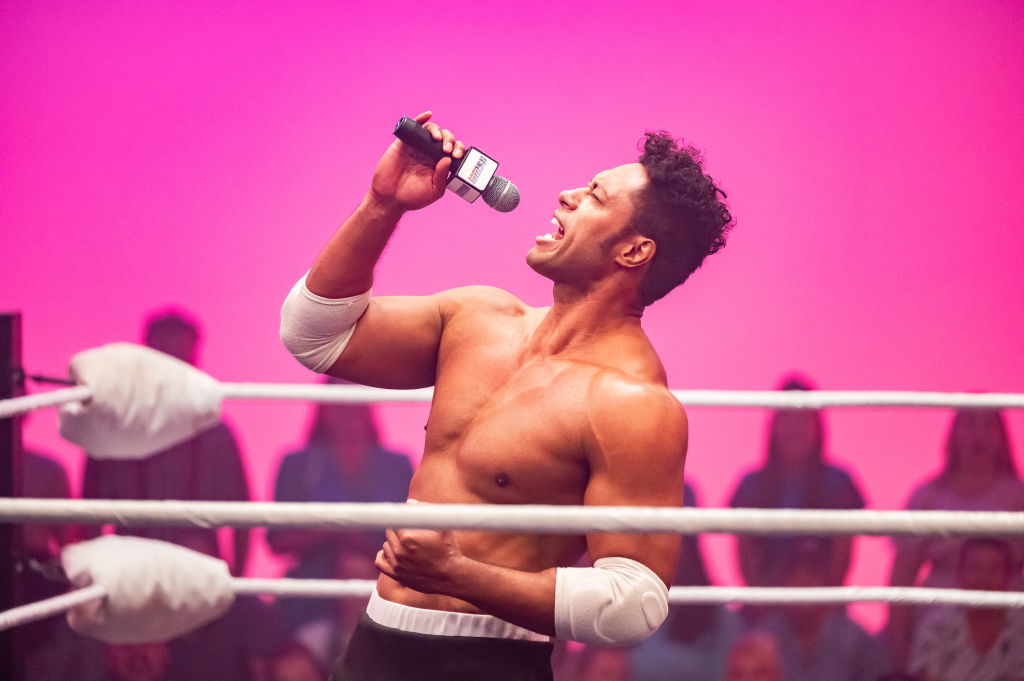 Wrestler celebrating in the ring with a microphone